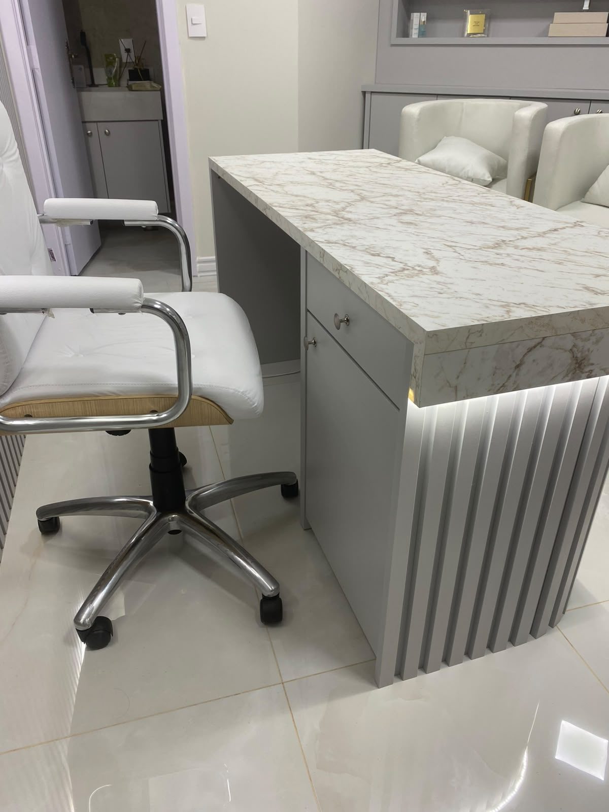 Consultório com mesa marmorizada e ripado com iluminação, foto 4 de 5